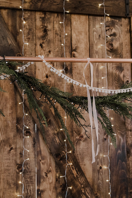 Winter Greenery Draping Over a Rustic Barn Door | Winter Holiday Party Decorations​ | Events Venue for a Holiday Party in Utah