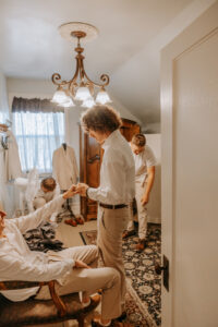 Four Groomsmen in Groom's Suit Getting Prepped | The Groom's Wedding Venue Amenities at Mill Pond Farms Events to Enjoy