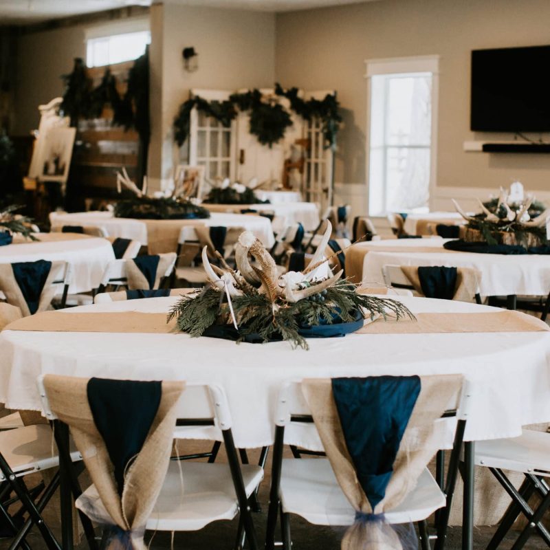 Navy Blue & Tan Wedding Table Decorated w/ Greenery & Antlers | Affordable Wedding Venues in Utah | Barn Venues Utah | Mill Pond Farms Events | Stansbury Lake, Utah